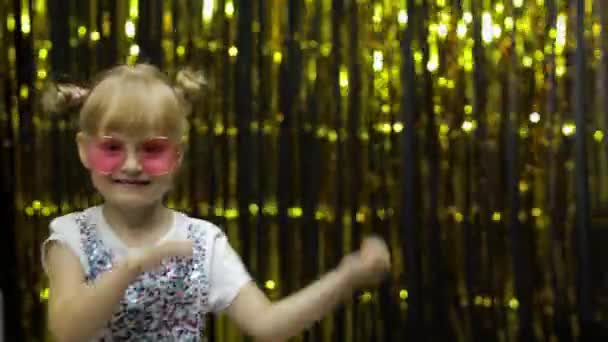 Child kid dancing, celebrating victory, fooling around. Girl posing on background with foil curtain — Stock Video