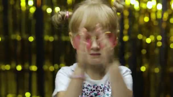 Enfant dansant, agitant les mains, faisant l'idiot. Fille posant sur le fond avec rideau de papier d'aluminium — Video