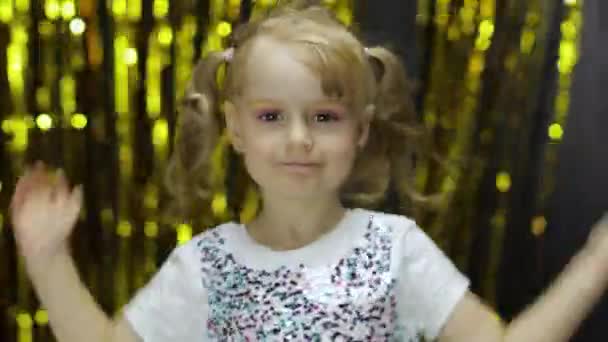 Child dancing, enjoying music, moving in dynamic winning dance. Girl 4-5 years old in shiny t-shirt — Stock Video