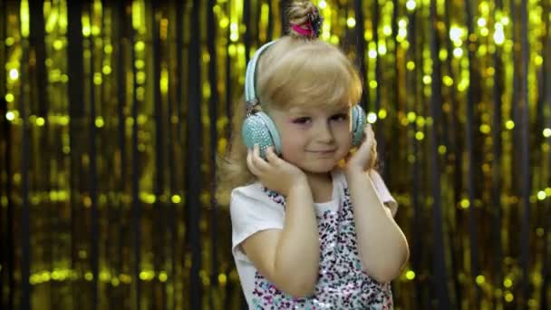 Gyerek táncol, zenét hallgat fejhallgatón. Gyerek lány tánc, miután hun, pihentető, élvezi — Stock videók