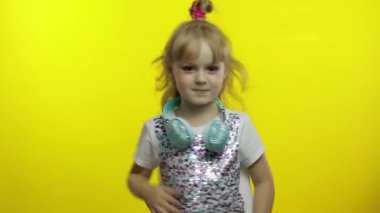 Çocuk dans eder, müzik dinler. Kulaklıklı küçük kız dans ediyor, eğleniyor, eğleniyor.