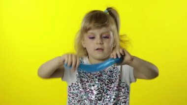 El yapımı balçıkla oynayan bir çocuk. Çocuk turkuaz balçık yaparken eğleniyor. Komik öğrenci kız.