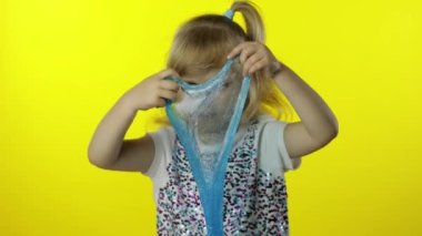 El yapımı balçıkla oynayan bir çocuk. Küçük kız turkuaz sümük yaparken eğleniyor. Stres önleyici