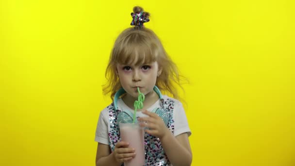 Stílusos gyerek tejkoktélt iszik szívószállal, és mutogatja a hüvelykujját. Hideg tejturmix ital — Stock videók