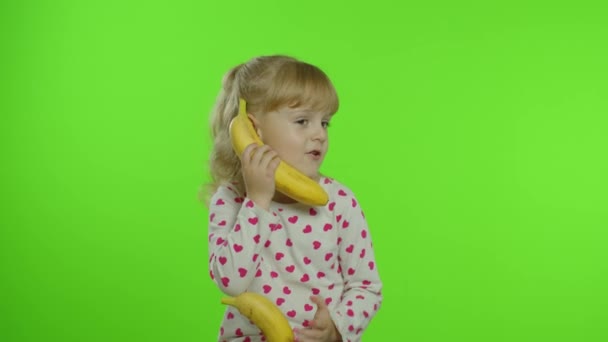 Enfant fille heureuse enfant imitant conversation téléphonique avec banane isolé sur fond de clé chromatique — Video