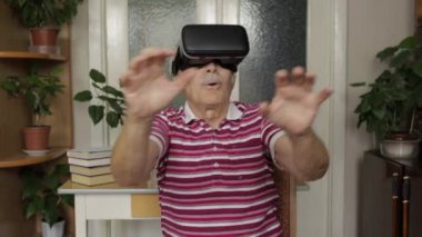 Sanal gözlüklü büyük baba evde 360 VR kasklı 3D video izliyor.