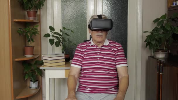 Starszy dziadek mężczyzna w wirtualnych okularach oglądanie 3d wideo w kasku 360 vr w domu — Wideo stockowe