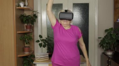 Sanal gözlüklü büyükannem video izliyor ve evde antrenman yapıyor.