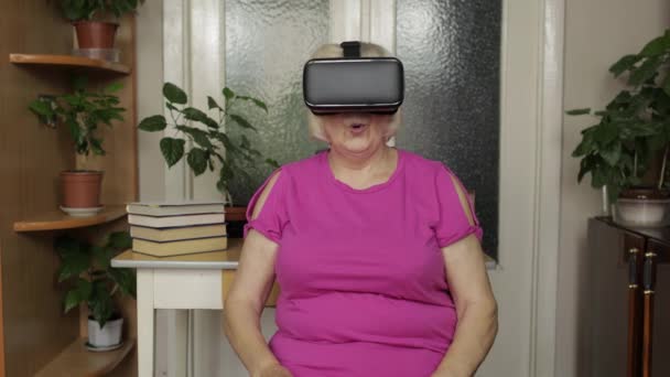 Senior mormor kvinna i virtuella headset glasögon titta på 3D-video i 360 vr hjälm hemma — Stockvideo