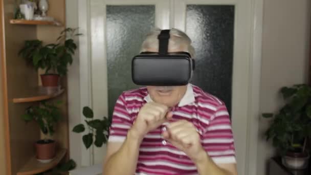 Avó em óculos de fone de ouvido virtual assistindo vídeo em caixa de treinamento de capacete VR, mostra luta punho — Vídeo de Stock