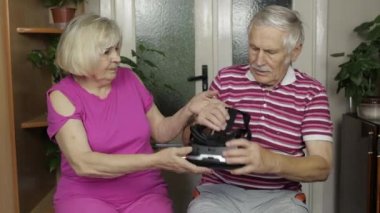 VR kulaklıklı büyükbaba ve büyükanne oyun oynuyorlar, sanal gerçeklik 3D video izliyorlar.