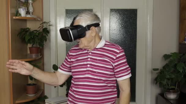 Senior grootvader man in virtuele headset bril kijken 3d video in 360 vr helm thuis — Stockvideo