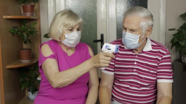Büyükbaba ve büyükanne sıcaklığı elektronik termometreyle ölçüyorlar. Coronavirus, Covid-19 — Stok video