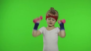 Spor giyimli beyaz bir kız halterle egzersiz yapıyor. Çocuklar için egzersiz. Atletik çocuk