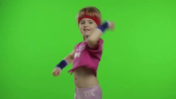 Menina bonito nova em sportswear fazendo ginasta fitness exercícios em casa. Treino para crianças. Criança desportiva — Vídeo de Stock