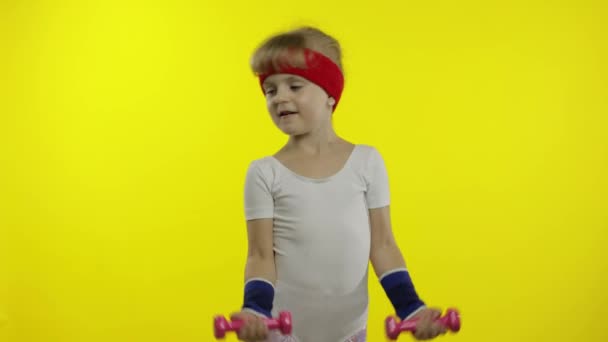 Ragazza caucasica in abbigliamento sportivo fare esercizi con manubri. Allenamento per bambini. Bambino atletico — Video Stock