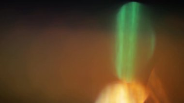 Işık sızıntısı 4K görüntüsü. Lens parlaklığı bokeh örtüleri, yanan alev arka planı. Flaş ışınları etkisi