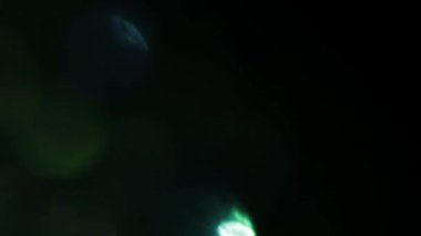 Çok renkli ışık siyah arkaplanda 4K görüntü sızdırıyor. Görüntüler, dönüşümler. Bokeh etkisi