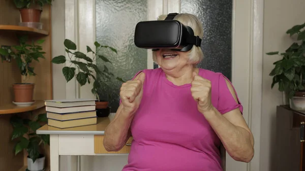 Abuela mayor mujer en gafas de auriculares virtuales viendo vídeo 3d en 360 vr casco en casa — Foto de Stock