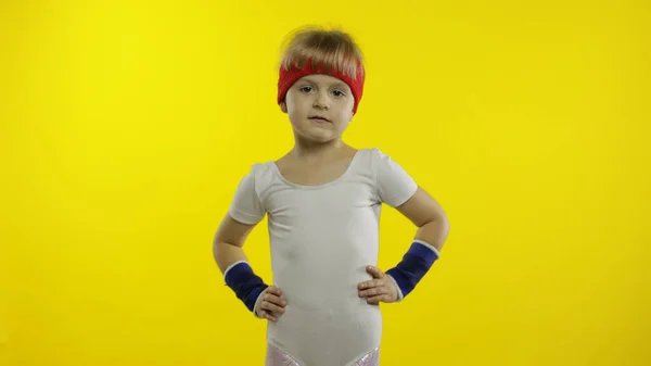 Chica joven en ropa deportiva haciendo ejercicios de gimnasta de fitness en casa. Entrenamiento para niños. Niño deportivo. — Foto de Stock