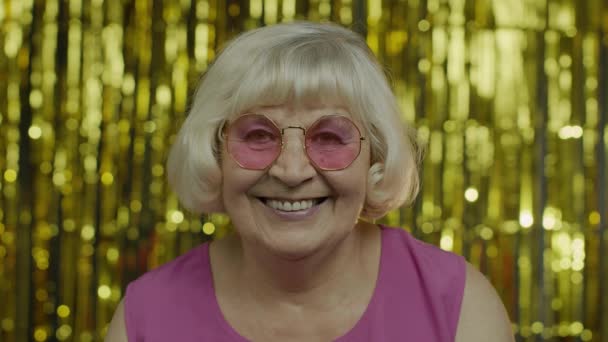Θετική ηλικιωμένη γυναίκα με γυαλιά ηλίου που απολαμβάνει, χαμογελά, ικανοποιημένη με τη ζωή, καλή διάθεση, επιτυχία — Αρχείο Βίντεο