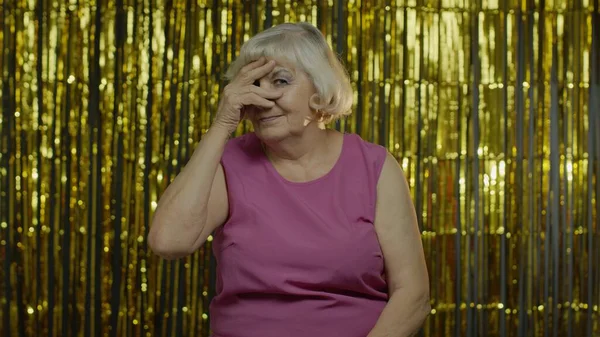 Retrato de anciana mayor con los ojos cerrados con la mano y espiando a través de los dedos, escondiéndose, espiando — Foto de Stock