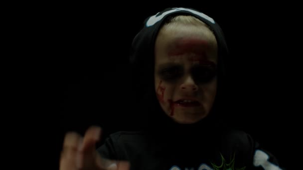 Halloween, fille en colère avec du sang sur le visage. Enfant habillé comme squelette effrayant, posant, faisant des visages — Video