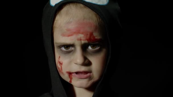 ハロウィン、顔に血の化粧をした怒っている女の子。怖いスケルトン姿の子供が顔を出し — ストック動画