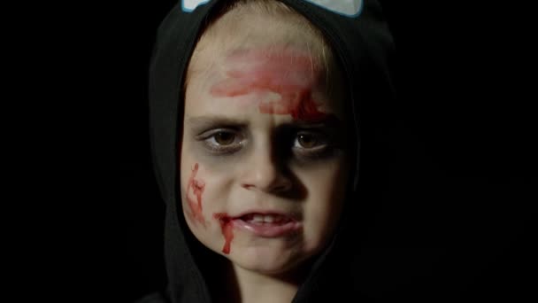 Halloween, arg tjej med blodmakeup i ansiktet. Kid klädd som skrämmande skelett, poserar, gör ansikten — Stockvideo