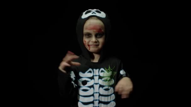 Halloween fille en colère avec du maquillage de sang sur le visage. Enfant habillé comme squelette effrayant, dansant, faisant des visages — Video