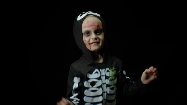 Halloween wściekła dziewczyna z makijażem krwi na twarzy. Dzieciak ubrany jak straszny szkielet, tańczący, robiący miny — Wideo stockowe
