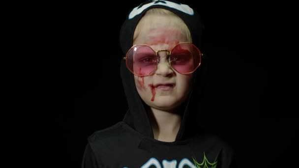 Halloween, fille en colère avec du sang sur le visage. Enfant habillé comme squelette effrayant, posant, faisant des visages — Video
