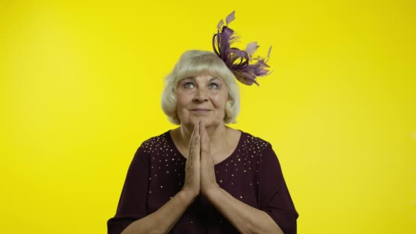 Olumlu yaşlı sarışın kadın kameraya başvuruyor, dua hareketlerini sürdürüyor ve yardım istiyor. — Stok video