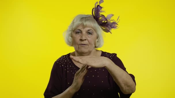 Втомлена старша жінка, що показує час, зупиняє жест, дивлячись на камеру з неприємним видом, дедлайн — стокове відео