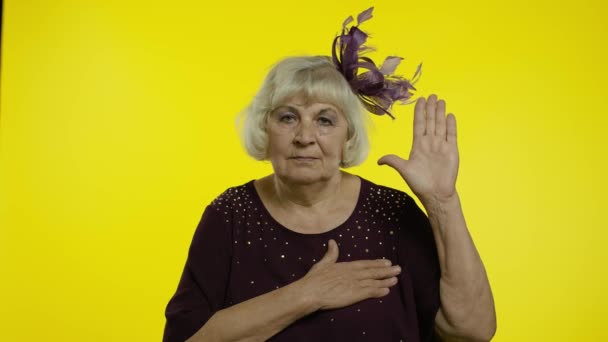 Eerlijke oude vrouw die haar hand opsteekt, de borst aanraakt en een gelofte aflegt, beloftes doet, zweert — Stockvideo