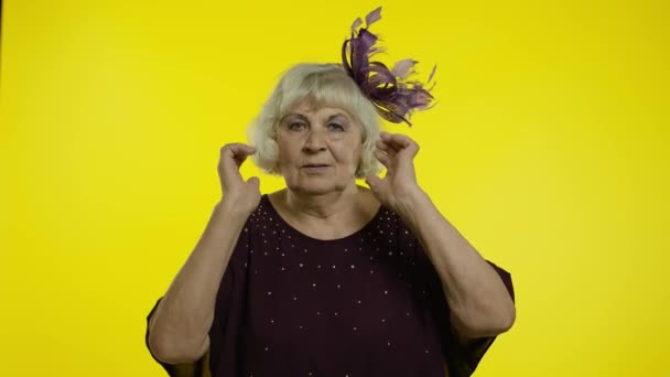 Sinirli yaşlı kadın kulaklarını kapatıyor ve el kol hareketi yapıyor. Hayır, tavsiyelerden kaçıyor, gürültüyü görmezden geliyor. — Stok video