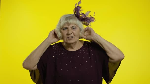 Zdenerwowana starsza pani zakrywająca uszy i gestykulująca nie, unikająca porad, ignorująca hałas — Wideo stockowe