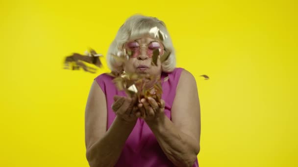 Gelukkig senior oude vrouw lachen, blazen confetti glitters, vieren verjaardag, winnende loterij — Stockvideo