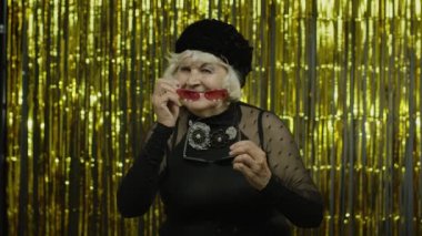 Güneş gözlüklü, mutlu, hayattan memnun, neşeli ve başarılı yaşlı bir kadın.