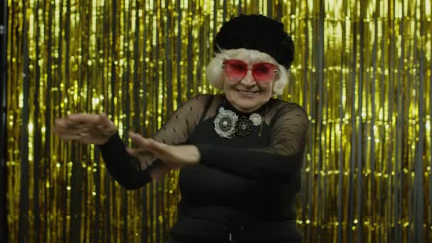 La vecchietta anziana balla, festeggia, ascolta musica. Energeticamente muovendosi al ritmo, rilassandosi — Video Stock