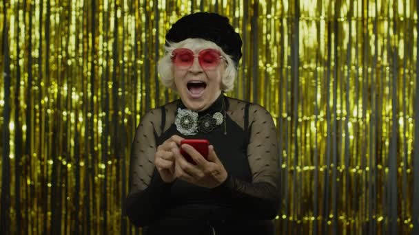Shocked anziana donna anziana digitando messaggio sul social network, utilizzando app, shopping online. Rallentatore — Video Stock