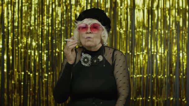 Ηλικιωμένοι στυλ ώριμη γιαγιά στη μόδα μαύρα ρούχα σε γυαλιά ηλίου που θέτουν, τσιγάρο καπνού — Αρχείο Βίντεο
