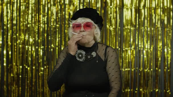 Elderly style mature woman in fashion black clothes in sunglasses posing, smoke cigarette — Stock Video