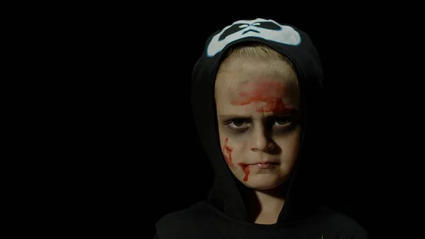 Halloween, menina zangada com maquiagem de sangue no rosto. Criança vestida de esqueleto assustador, posando, fazendo rostos — Fotografia de Stock