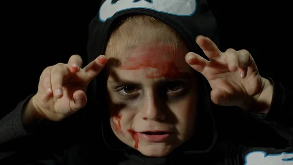 Halloween, wütendes Mädchen mit blutverschmiertem Gesicht. Kind als beängstigendes Skelett verkleidet, posiert, macht Gesichter — Stockfoto