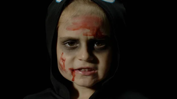 Halloween, angry girl with blood makeup on face. Kid dressed as scary skeleton, posing, making faces — Stock Photo, Image