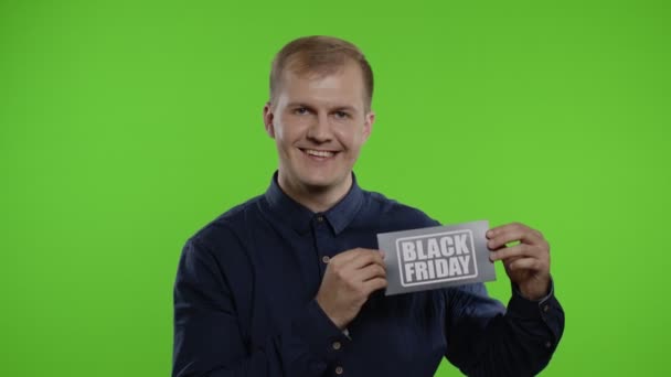 Fröhlicher Mann zeigt Black-Friday-Aufschrift, lächelt zufrieden mit niedrigen Preisen — Stockvideo