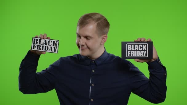 Homem alegre mostrando duas notas de inscrição Black Friday, sorrindo olhando satisfeito com preços baixos — Vídeo de Stock