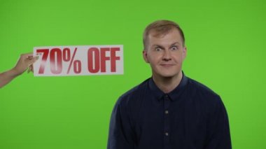 % 70 indirimli yazı gülümseyen adamın yanında görünüyor. Adam indirimleri kutluyor. Kara Cuma