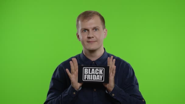 Homem animado mostrando Black Friday nota de inscrição, sorrindo olhando satisfeito com preços baixos — Vídeo de Stock